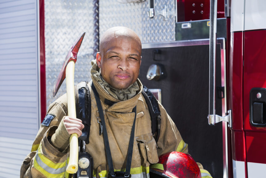 firefighter wearing contaminated turnout gear poses for photo