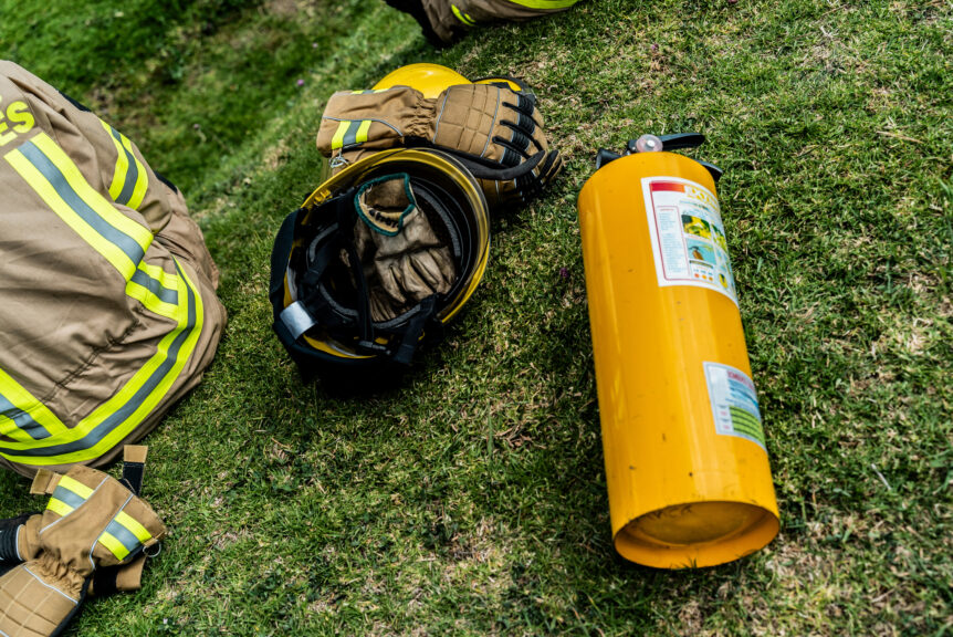Firefighter gear of SCBA tank, helmet, and gloves sit dirty after a response