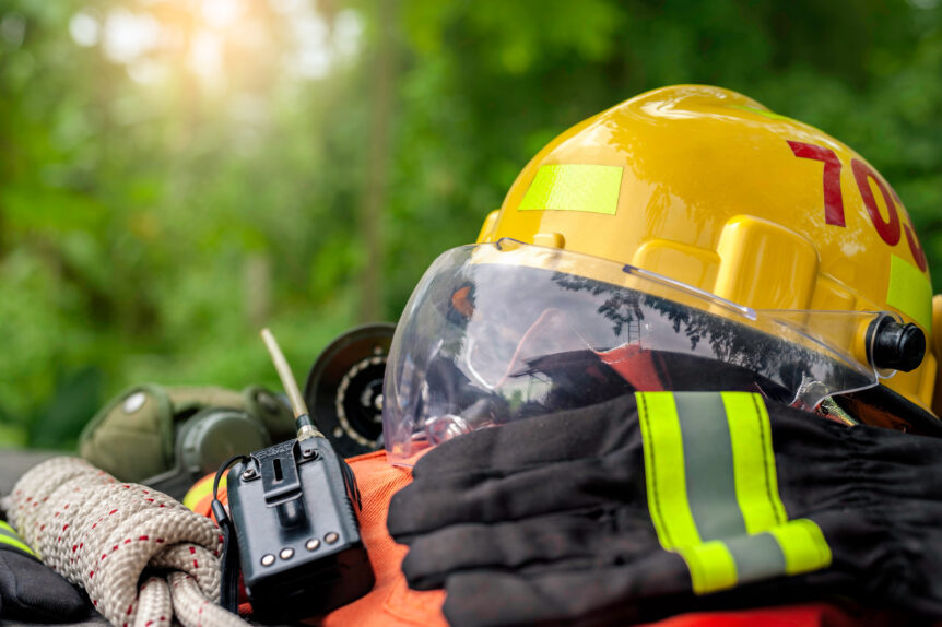 Firefighter gear, including helmet and gloves, sit waiting on a table