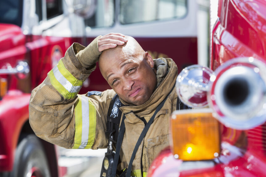 Firefighter wipes sweat off while wearing full PPE turnout gear